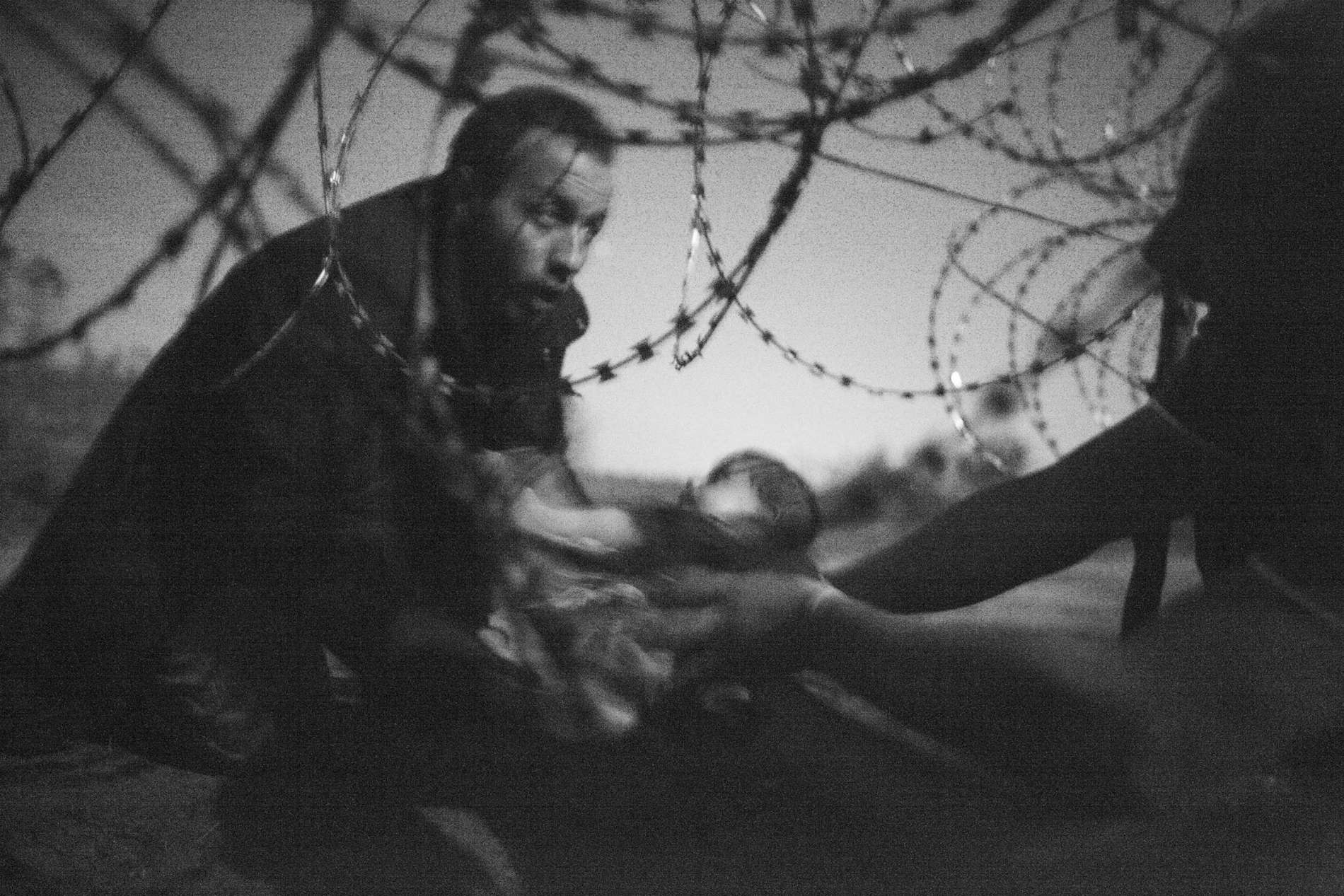World Press Photo of the Year Warren Richardson, Australia, 2015, Hope for a New Life A man passes a baby through the fence at the Serbia/Hungary border in Röszke, Hungary, 28 August 2015