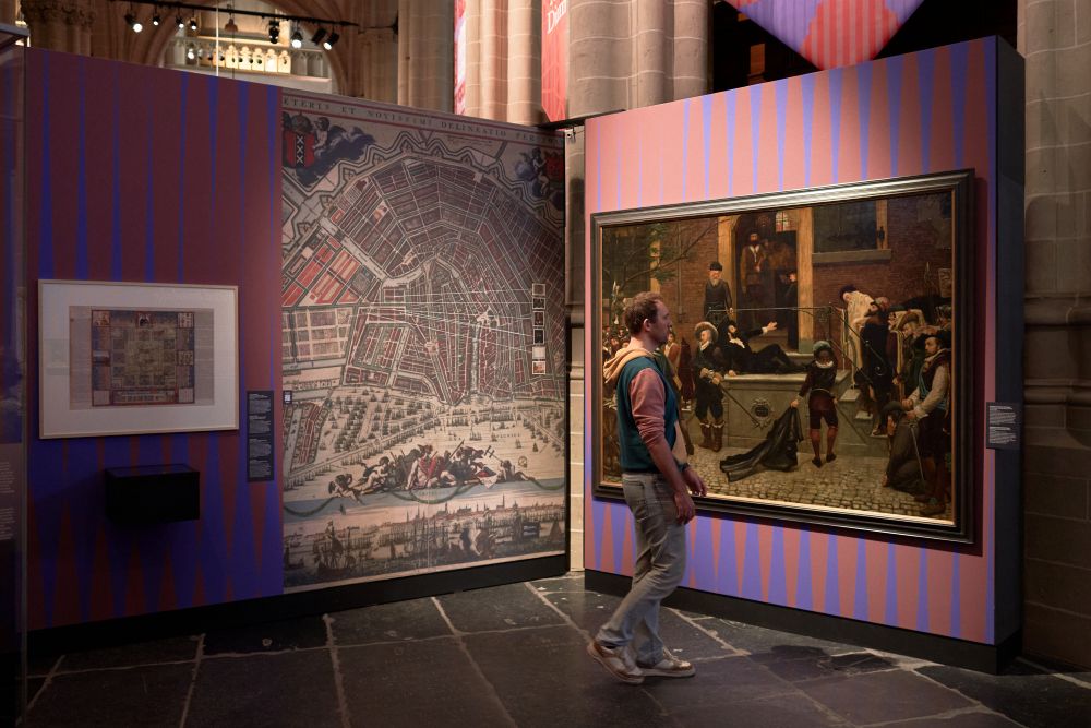 Man bezoekt de tentoonstelling Mokum, de biografie van Joods Amsterdam in De Nieuwe Kerk