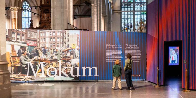 Moeder en kind bezoeken de tentoonstelling Mokum, de biografie van Joods Amsterdam in De Nieuwe Kerk